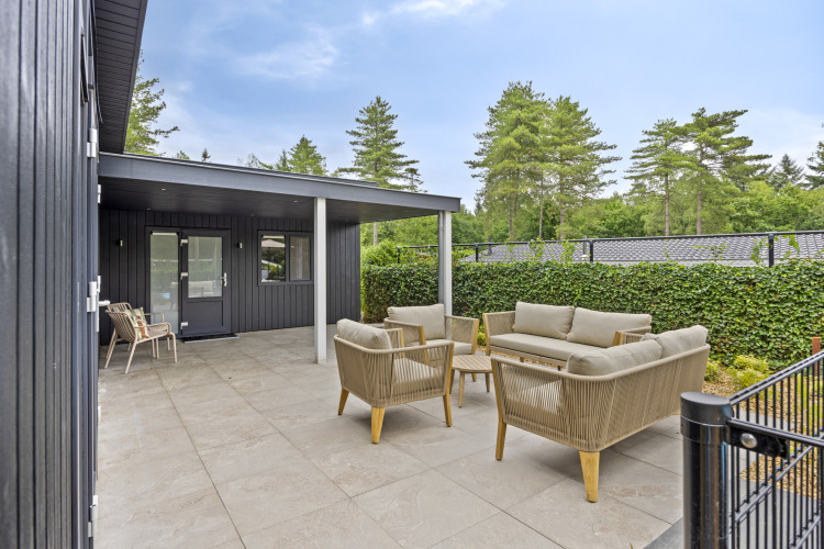 Terrasse mit modernen Sitzmöbeln an einer 10-Personen-Lodge mit Gästehaus bei De Thijmse Berg, Niederlande.