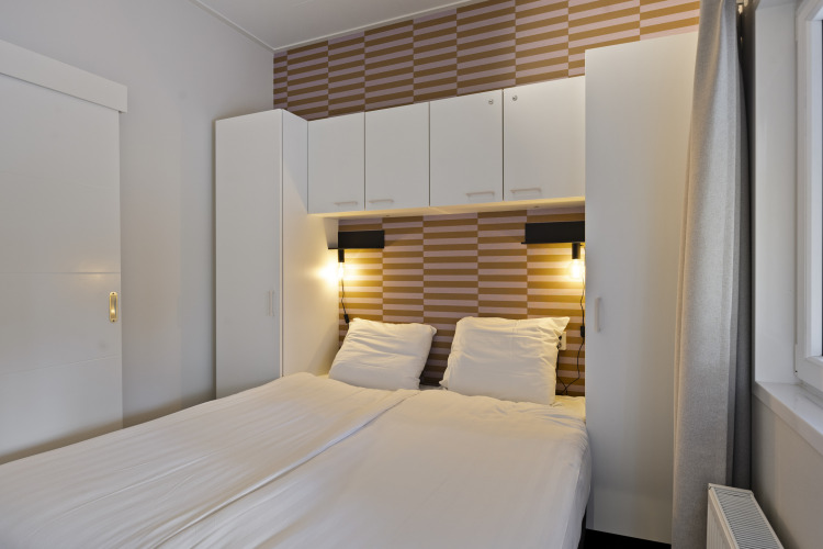 Modernes Schlafzimmer in einer 10-Personen-Lodge mit Einbauschränken und Doppelbett bei De Thijmse Berg.