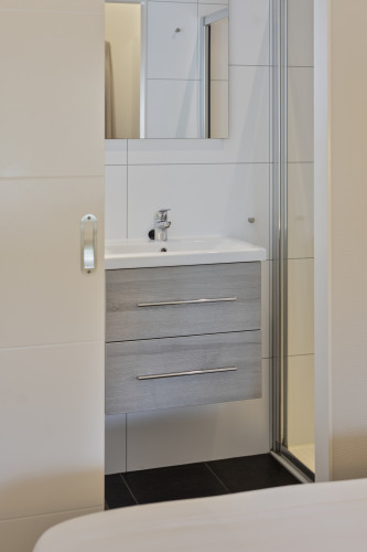 Modernes Badezimmer mit Waschbecken, Spiegel und Schubladenschrank in einer 10-Personen-Lodge bei De Thijmse Berg.