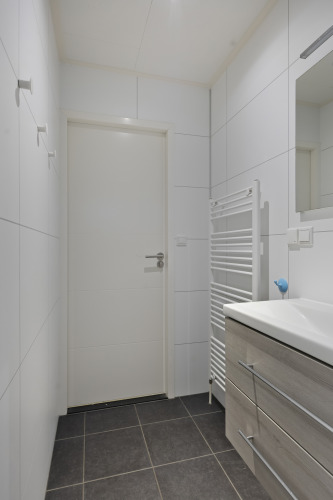 Modernes Badezimmer in einer Lodge am De Thijmse Berg in den Niederlanden mit weißen Fliesen und Waschtisch.