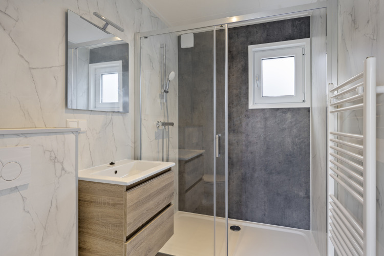 Modernes Badezimmer mit Glasdusche, Holzwaschtisch und Marmordekor im De Thijmse Berg-Lodge, Niederlande.