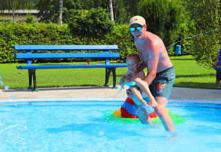 Un uomo e un bambino giocano insieme in piscina al Campingpark Echternacherbrück in Renania-Palatinato, Germania.