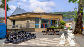 Großes Gartenschachspiel vor einem modernen Gebäude im Campingpark Echternacherbrück, Rheinland-Pfalz.