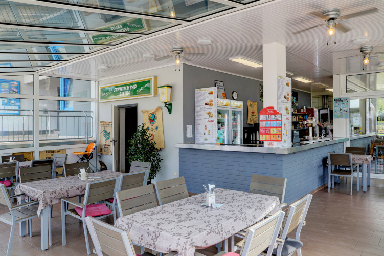 Zona bistrot interna del Campingpark Echternacherbrück in Germania con tavoli moderni e atmosfera rilassante.