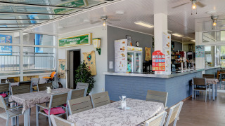 Modernes Bistro im Campingpark Echternacherbrück mit Sitzbereichen, Theke und hellem, gemütlichem Ambiente.