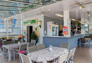 Espace bistro intérieur du Campingpark Echternacherbrück avec tables modernes et atmosphère conviviale.