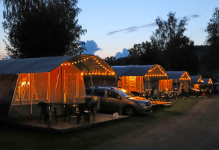 Oplyste telte og biler om aftenen i Campingpark Echternacherbrück, Rhineland-Pfalz, Tyskland.