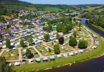 Aerial view of Echternacherbrück campsite in Germany, showing the river, campers, and nearby houses.