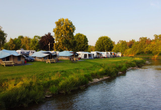 Campingpark Echternacherbrück sul fiume, con tende, roulotte e tanto verde in un campeggio in Germania.