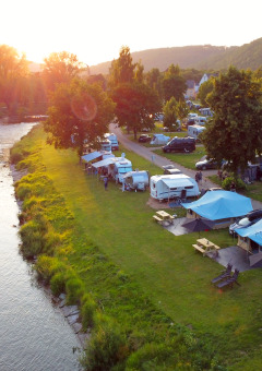 Campingpark Echternacherbrück in Renania-Palatinato, Germania, con tende e caravan vicino al fiume.