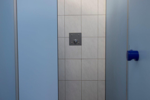 Cabine de douche aux murs bleu clair et mur du fond carrelé au Campingpark Echternacherbrück, Allemagne.