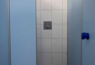 Shower cubicle with light blue walls and tiled back wall in Campingpark Echternacherbrück, Germany.