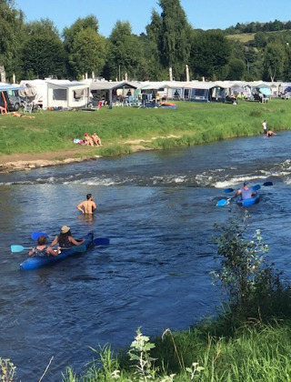Vakantiegangers genieten van kajakken en zwemmen in de rivier bij Campingpark Echternacherbrück.