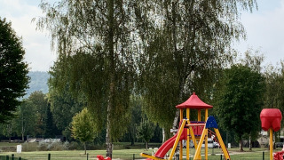 Spielplatz mit Rutsche und Schaukeln im Campingpark Echternacherbrück, Rheinland-Pfalz, Deutschland.