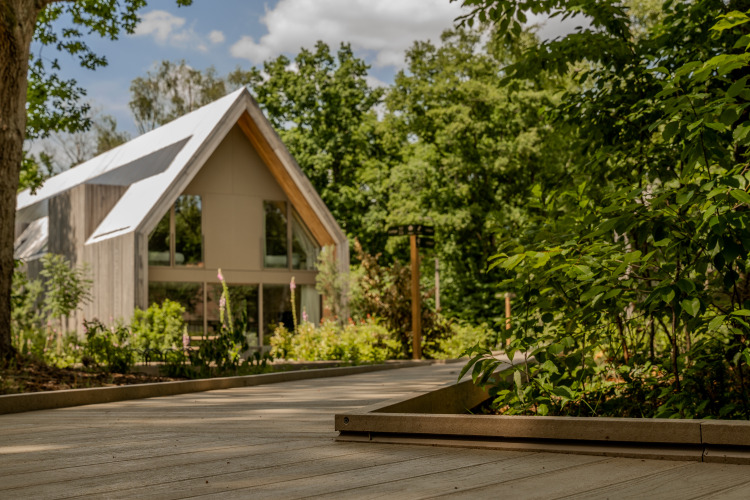 Un albergue moderno con grandes ventanales y techo a dos aguas rodeado de bosque en Woodz Lodges, Bélgica.