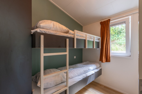 Camera con letto a castello, scala in legno, finestra e tenda arancione al Family Lodge + hot tub, De Thijmse Berg.