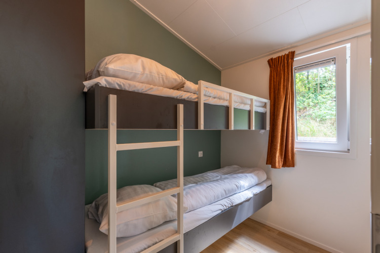 Room with a bunk bed, wooden ladder, window, and orange curtain at Family Lodge + hot tub, De Thijmse Berg.