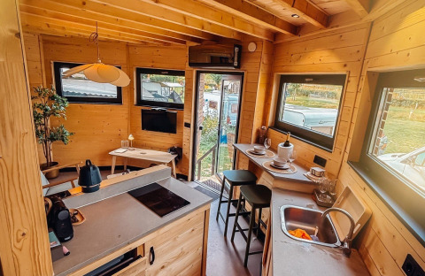 Interior de una acogedora cabaña en Wellnest, Camping Vinkenhof, Países Bajos, con cocina y comedor.