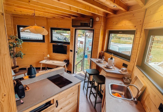 Interior de una acogedora cabaña en Wellnest, Camping Vinkenhof, Países Bajos, con cocina y comedor.