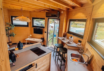Binnenkant van een gezellige lodge bij Wellnest, Camping Vinkenhof in Nederland met keuken en zithoek.