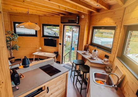 Interieur van een knusse lodge bij Wellnest, Camping Vinkenhof in Nederland met keuken en zitgedeelte.