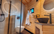 Salle de bain moderne avec murs en bois, douche, toilettes et lavabo en pierre, Wellnest, Camping Vinkenhof, Pays-Bas.