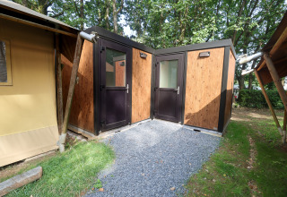 Tente safari au Camping Fuussekaul au Luxembourg avec façade boisée et deux portes d'entrée modernes distinctes.