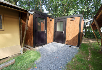 Safari telt på Camping Fuussekaul i Luxembourg med træfacade og separate indgangsdøre i naturlig omgivelser.