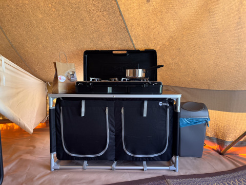 Angolo cottura con fornello a gas, pentola e pattumiera in una tenda tipi al Camping Fuussekaul, Lussemburgo.