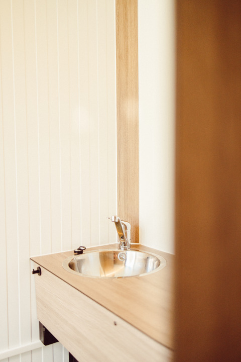 Évier moderne avec plan en bois et cuve en métal dans la salle de bain de Camping Liefrange, Luxembourg.