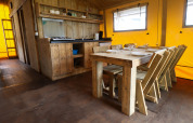 Rustieke keuken en eethoek in safaritent bij Camping Liefrange in Luxemburg met houten meubilair.