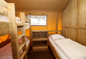 Interior view of a safari tent cabin with bunk bed and single bed at Camping Liefrange in Luxembourg.