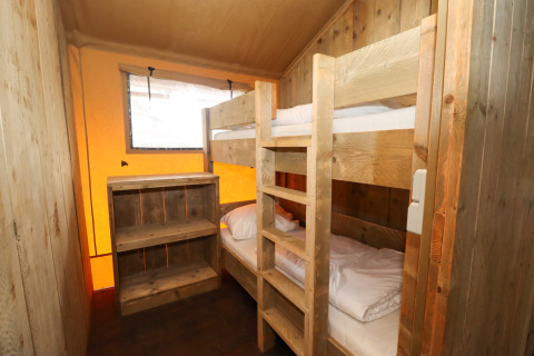 Kleines Schlafzimmer mit Etagenbett und Holzregal in einem Safarizelt auf Camping Liefrange, Luxemburg.