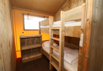 Small bedroom with bunk beds and wooden shelves inside a safari tent at Camping Liefrange, Luxembourg.