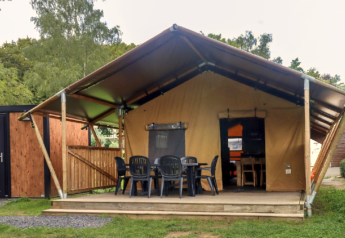 Safariinspireret telt på Camping Liefrange med udendørs siddeplads foran, omgivet af træer og natur.