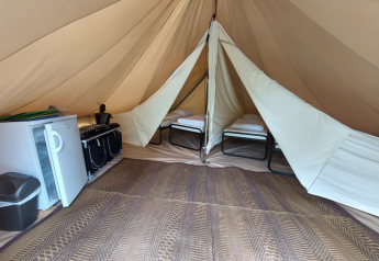 Innenansicht des Camping Liefrange - Tipi Tent mit Betten, Kühlschrank und Herd in Luxemburg.