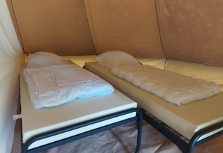 Due letti singoli con piumini in un tipì al Camping Liefrange in Lussemburgo, atmosfera da campeggio.