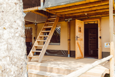 Ingresso tenda safari con scala di legno e porta aperta al Camping Liefrange - Ranger Lodge in Lussemburgo.