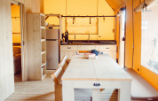 Interno tenda safari Camping Liefrange, Ranger Lodge, Lussemburgo, con cucina, tavolo e panche in legno.