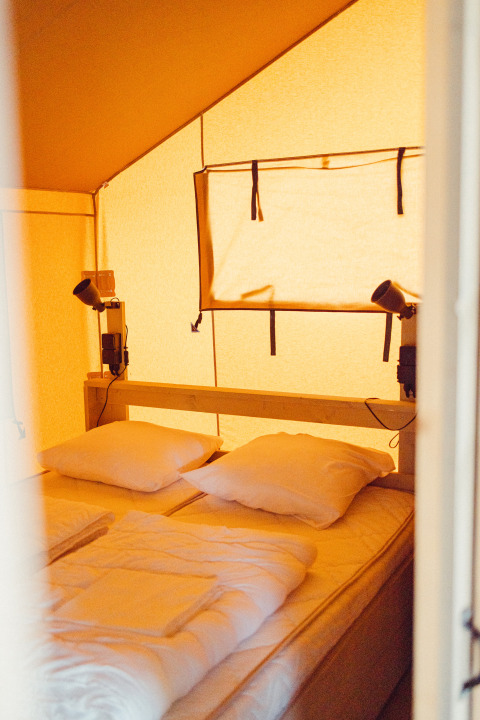 Intérieur d'une tente safari au Camping Liefrange - Ranger Lodge, avec lits jumeaux et oreillers au Luxembourg.