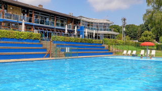 Piscina all'aperto nel parco vacanze di Diekirch, Lussemburgo, con lettini e strutture moderne sullo sfondo.