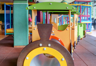 Aire de jeux intérieure avec structure en forme de train au parc de vacances Auf Kengert à Diekirch, Luxembourg.