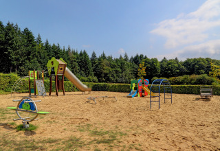 Parco giochi al villaggio Auf Kengert, Diekirch, Lussemburgo, con scivoli, arrampicate e sabbia.