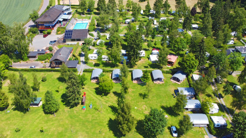 Luchtfoto van vakantiedomein Auf Kengert in Diekirch, Luxemburg, met zwembad, tenten en groene zones.