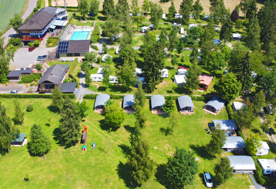 Luchtfoto van vakantiedomein Auf Kengert in Diekirch, Luxemburg, met zwembad, tenten en groene zones.