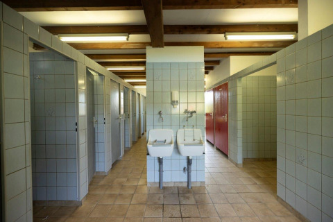 Gemeenschappelijke badkamer met douches en wastafels in Auf Kengert vakantiepark, Diekirch, Luxemburg.