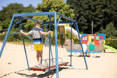 Un garçon joue sur une aire de jeux sablonneuse au parc de vacances Auf Kengert à Diekirch, Luxembourg.