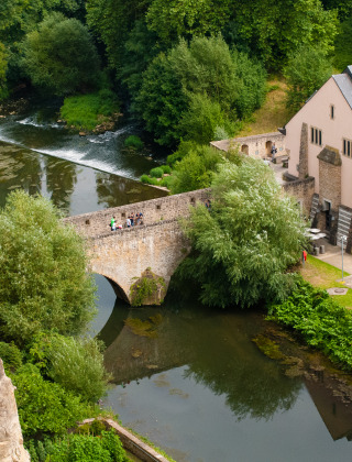 Vista pittoresca vicino a Larochette, Diekirch, Lussemburgo, con ponte di pietra, fiume e vegetazione.