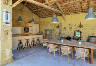 Cucina e sala da pranzo rustica all'aperto al Domaine La Barbe in Occitania, Francia, con arredi in legno.