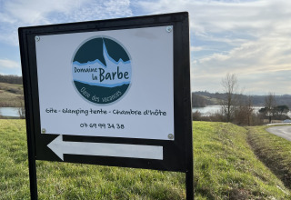 Cartel en Domaine La Barbe en Occitanie, Francia, indicando alojamiento en parque vacacional.